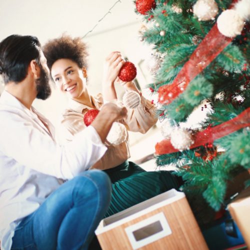 Casal arrumando a árvore de Natal